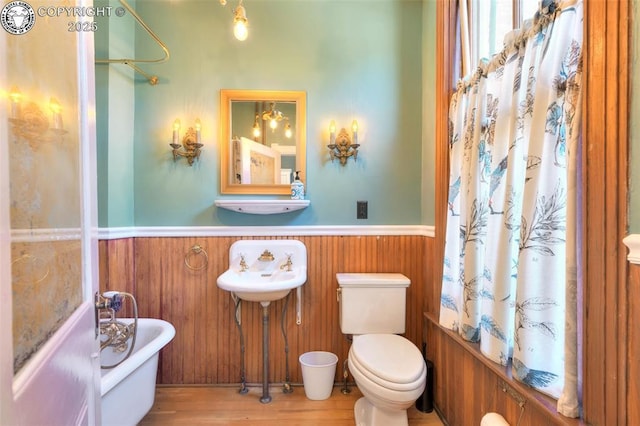 417 Greenwood Ave, Canon City, CO 81212 - bathroom with wainscoting, a freestanding tub, and wood finished floors
