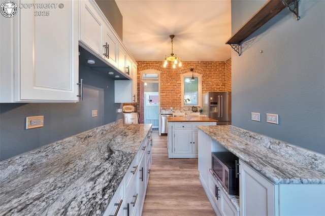 417 Greenwood Ave, Canon City, CO 81212 - kitchen featuring high end refrigerator, white cabinets, light wood-type flooring, brick wall, and light stone counters