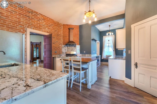 417 Greenwood Ave, Canon City, CO 81212 - kitchen with wall chimney range hood, a chandelier, dark wood-style flooring, stainless steel appliances, and pendant lighting