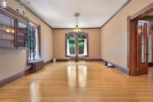 417 Greenwood Ave, Canon City, CO 81212 - spare room featuring radiator heating unit, light wood-style flooring, ornamental molding, and a chandelier