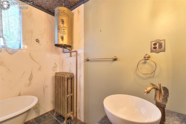 417 Greenwood Ave, Canon City, CO 81212 - bathroom with radiator, water heater, a freestanding bath, and an ornate ceiling