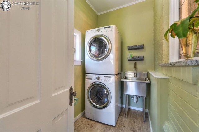 417 Greenwood Ave, Canon City, CO 81212 - laundry area with stacked washing machine and dryer, light wood-style floors, and crown molding