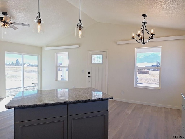 kitchen with stone countertops, pendant lighting, and a textured ceiling