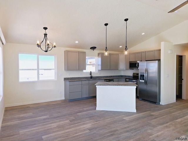 kitchen with stainless steel appliances, decorative light fixtures, a kitchen island, and gray cabinetry