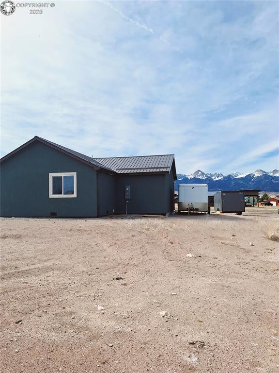 138 Jerry Dr, Westcliffe, CO 81252 - rear view of property with metal roof, a mountain view, and driveway