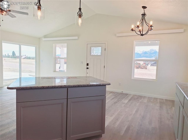 138 Jerry Dr, Westcliffe, CO 81252 - kitchen with lofted ceiling, gray cabinets, ceiling fan with notable chandelier, light stone counters, and light wood finished floors