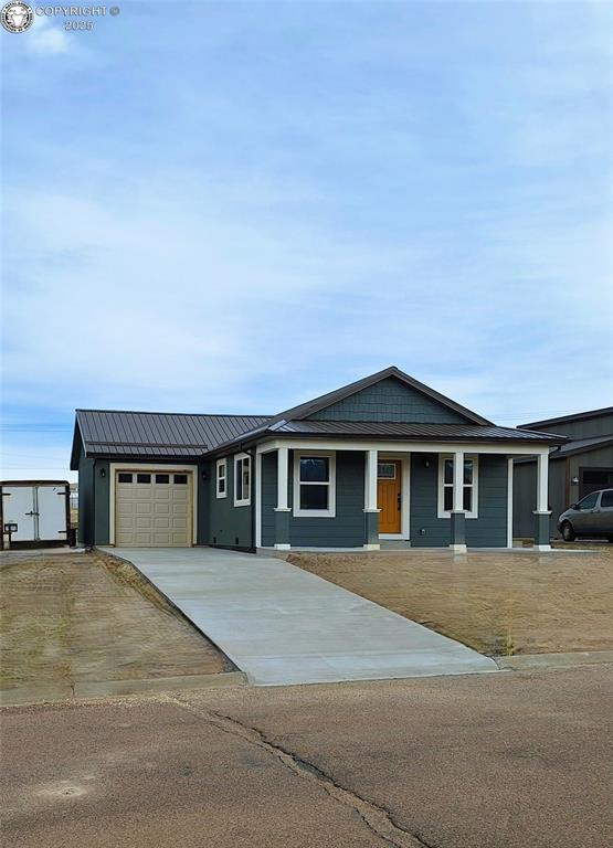 138 Jerry Dr, Westcliffe, CO 81252 - view of front of property featuring metal roof, a garage, and concrete driveway