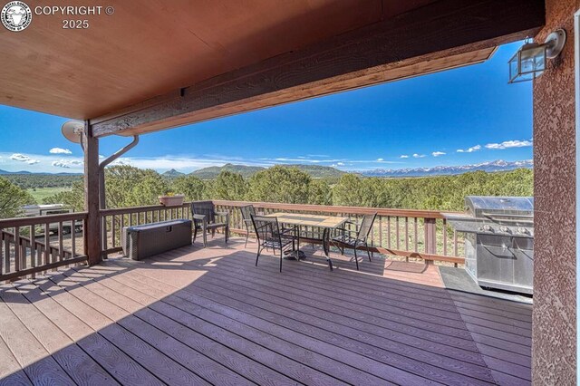 2680 Wild Bill Blvd, Westcliffe, CO 81252 - wooden deck with outdoor dining space, a mountain view, and grilling area