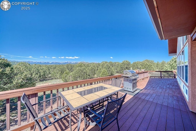 2680 Wild Bill Blvd, Westcliffe, CO 81252 - wooden deck with outdoor dining space, area for grilling, and a forest view
