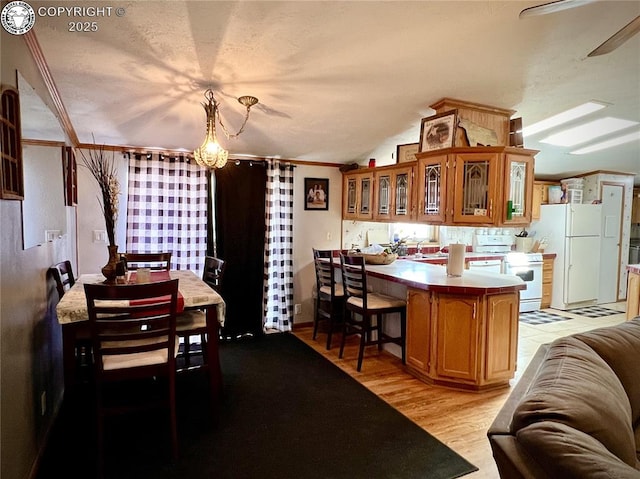 925 C St, Penrose, CO 81240 - kitchen featuring white appliances, brown cabinetry, glass insert cabinets, and a peninsula