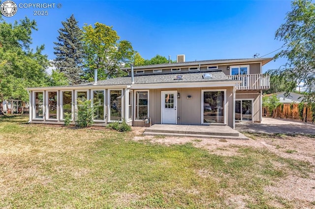 back of house featuring a patio, a sunroom, and a yard