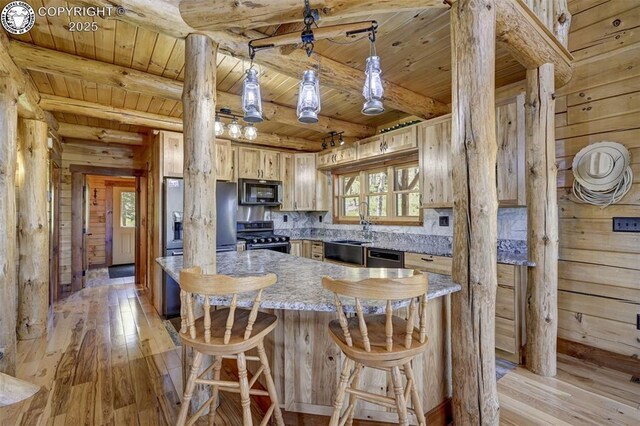 540 County Road 356, Westcliffe, CO 81252 - kitchen featuring stainless steel appliances, a sink, light wood-style flooring, wooden ceiling with exposed beams, and decorative columns