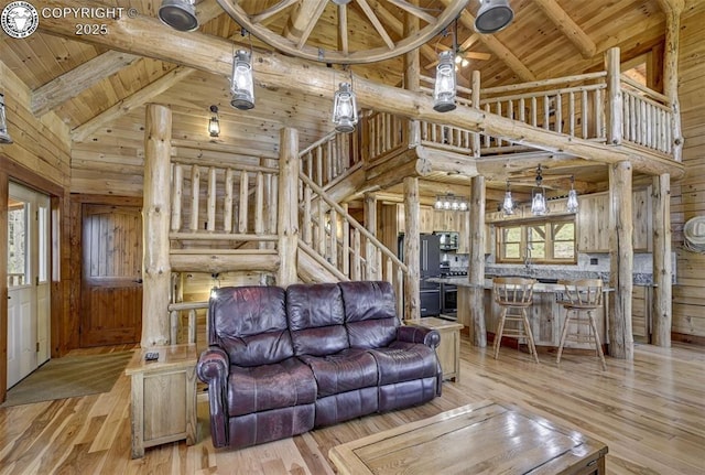540 County Road 356, Westcliffe, CO 81252 - living room featuring high vaulted ceiling, wood ceiling with exposed beams, wood finished floors, stairs, and wood walls