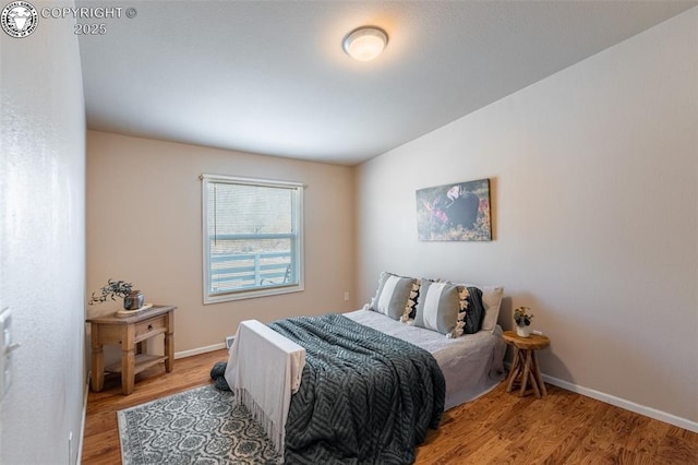bedroom featuring baseboards and wood finished floors