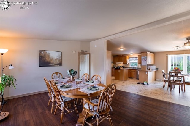 dining room featuring visible vents, baseboards, ceiling fan, and wood finished floors