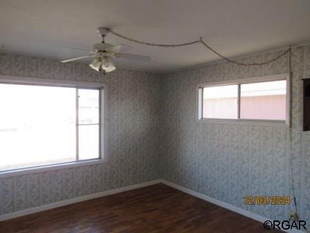 spare room with dark hardwood / wood-style floors and ceiling fan