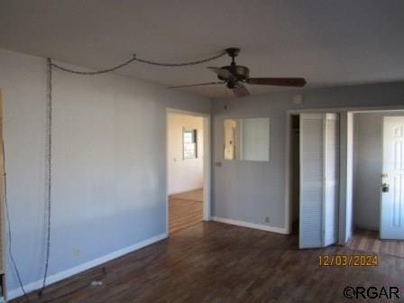 unfurnished bedroom with a ceiling fan, baseboards, and wood finished floors