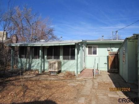 back of house with central AC unit and a sunroom