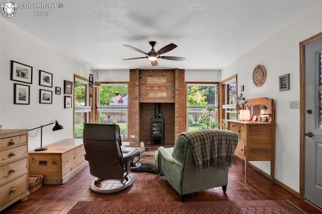 1124 Grand Ave, Canon City, CO 81212 - living room featuring a wood stove, healthy amount of natural light, a ceiling fan, and a textured ceiling