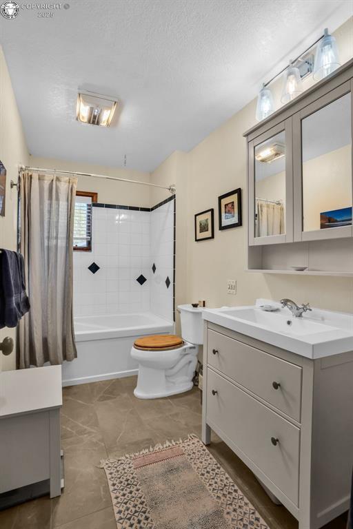 1124 Grand Ave, Canon City, CO 81212 - bathroom with vanity, shower / bath combo with shower curtain, and a textured ceiling