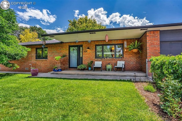 1124 Grand Ave, Canon City, CO 81212 - view of front facade featuring a front lawn, covered porch, and brick siding