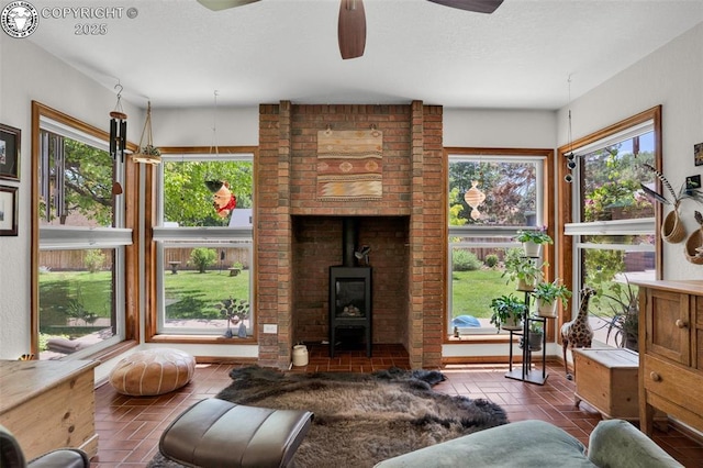 1124 Grand Ave, Canon City, CO 81212 - living area with ceiling fan, a wood stove, and a textured ceiling
