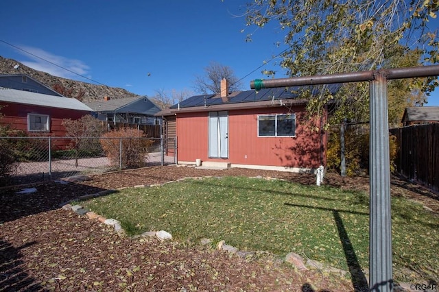 back of property with a yard and an outdoor structure