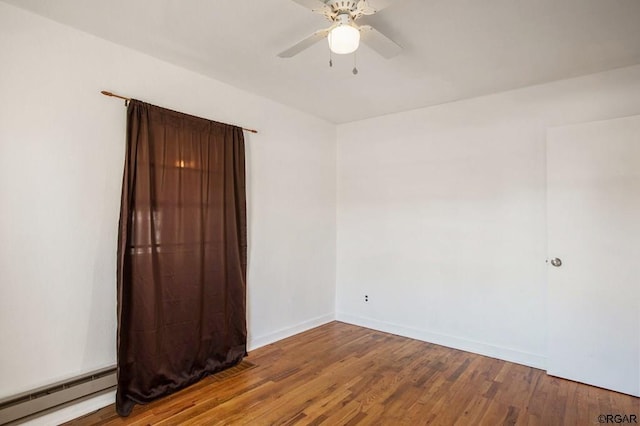 spare room featuring hardwood / wood-style floors, ceiling fan, and baseboard heating