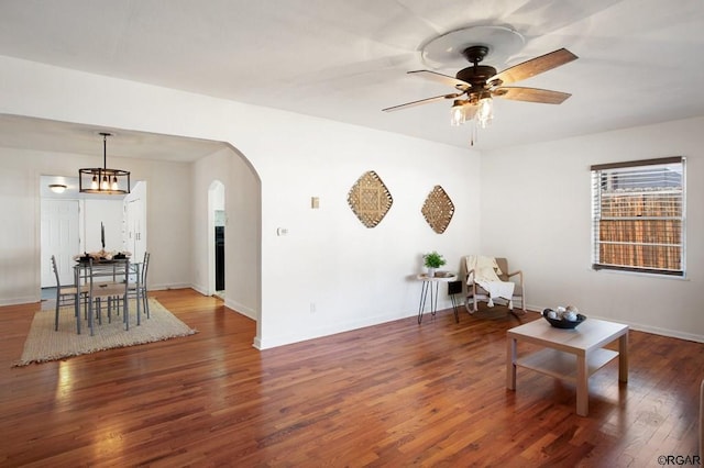 living area featuring dark hardwood / wood-style floors and ceiling fan with notable chandelier