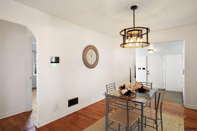 dining space featuring a notable chandelier and wood-type flooring