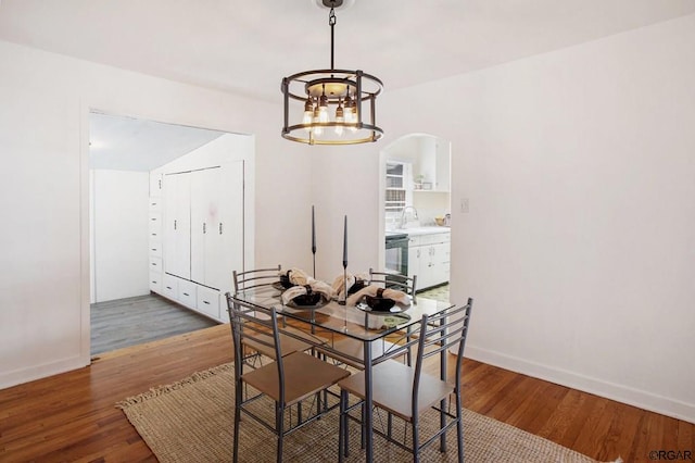 dining room with an inviting chandelier, dark hardwood / wood-style floors, and sink