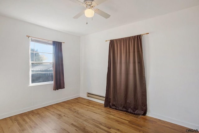 spare room featuring baseboard heating, ceiling fan, and light hardwood / wood-style floors