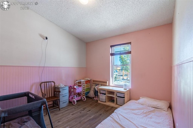 bedroom with hardwood / wood-style floors and a textured ceiling