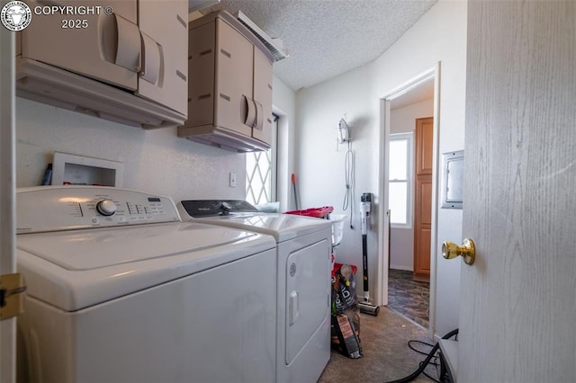 laundry room featuring cabinets, washer and dryer, and a textured ceiling