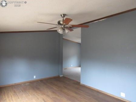 unfurnished room with baseboards, crown molding, ceiling fan, and wood finished floors