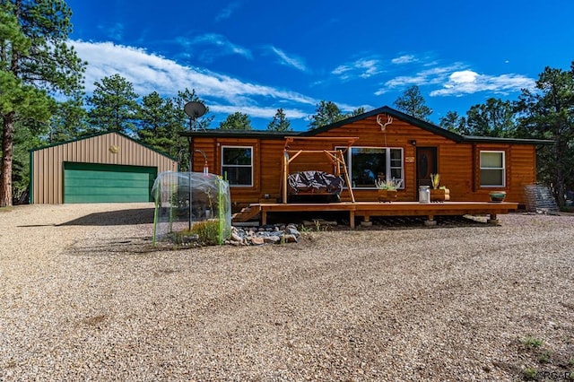 log cabin featuring a garage and an outbuilding