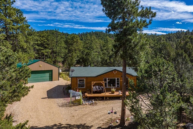 log cabin featuring a wooden deck, a garage, and an outdoor structure