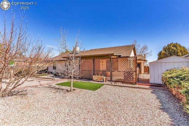 rear view of property with a shed, a patio, and an outdoor structure