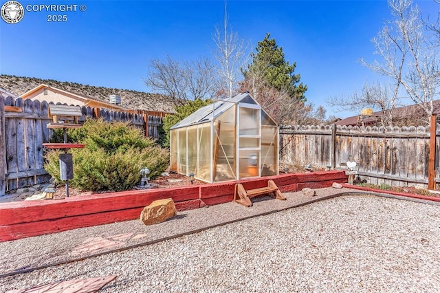 view of yard featuring an outdoor structure, a fenced backyard, and an exterior structure