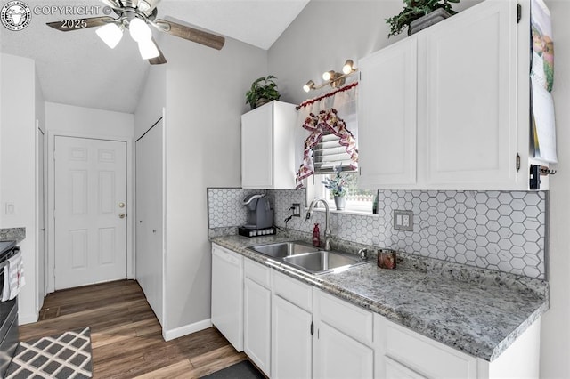 kitchen featuring tasteful backsplash, dishwasher, wood finished floors, white cabinetry, and a sink