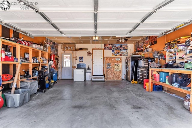 garage with a workshop area, a garage door opener, and fridge