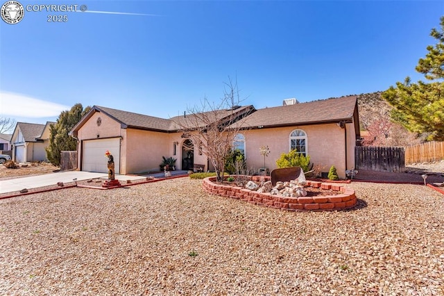 ranch-style home with stucco siding, concrete driveway, an attached garage, and fence