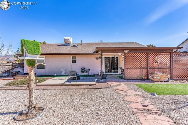 rear view of house with stucco siding and a patio