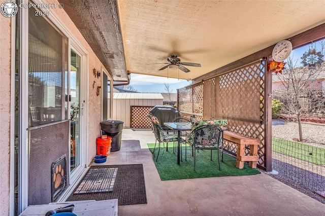 view of patio / terrace with outdoor dining space, an outdoor structure, a storage unit, and ceiling fan