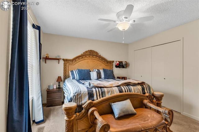 bedroom featuring a ceiling fan, visible vents, carpet, a closet, and a textured ceiling