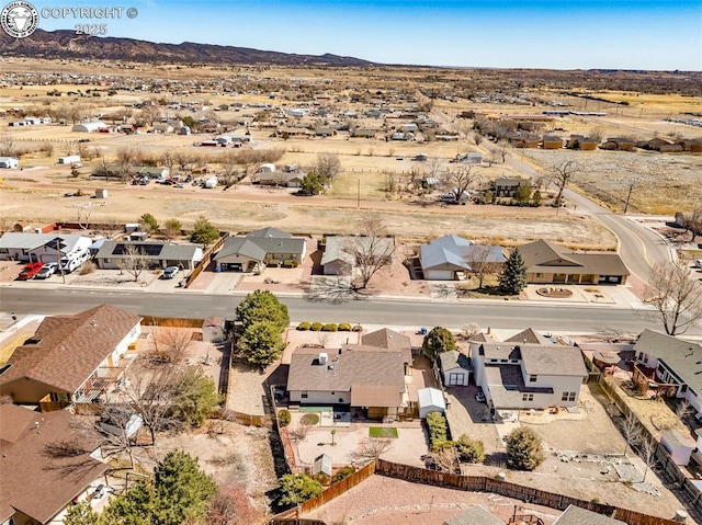 drone / aerial view featuring a desert view, a mountain view, and a residential view