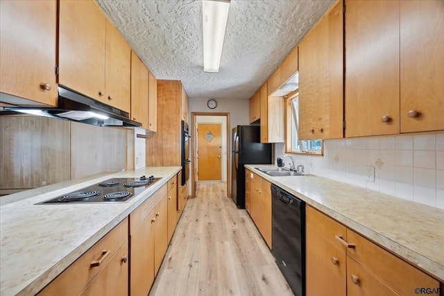 kitchen featuring sink, tasteful backsplash, a textured ceiling, light wood-type flooring, and black appliances