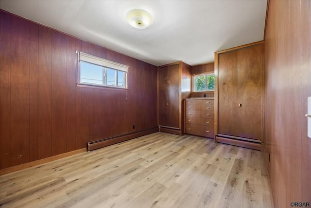 spare room with a baseboard radiator and light hardwood / wood-style flooring