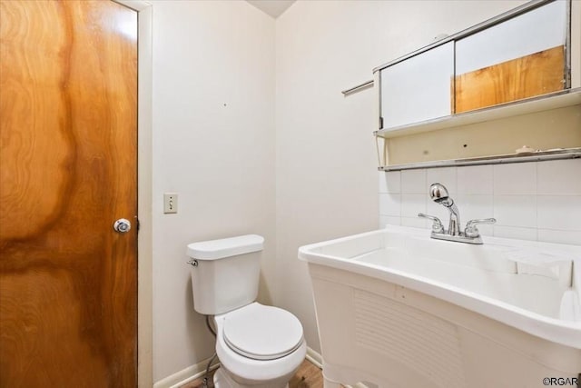 bathroom featuring tasteful backsplash, sink, and toilet