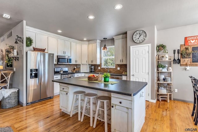 kitchen with pendant lighting, white cabinetry, and stainless steel appliances